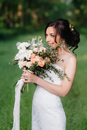 Smiling Bride and Groom with Flower Bouquet in Garden