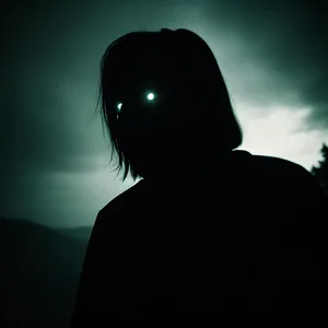 Silhouette of a Dark-Faced Man Holding Lighting Equipment