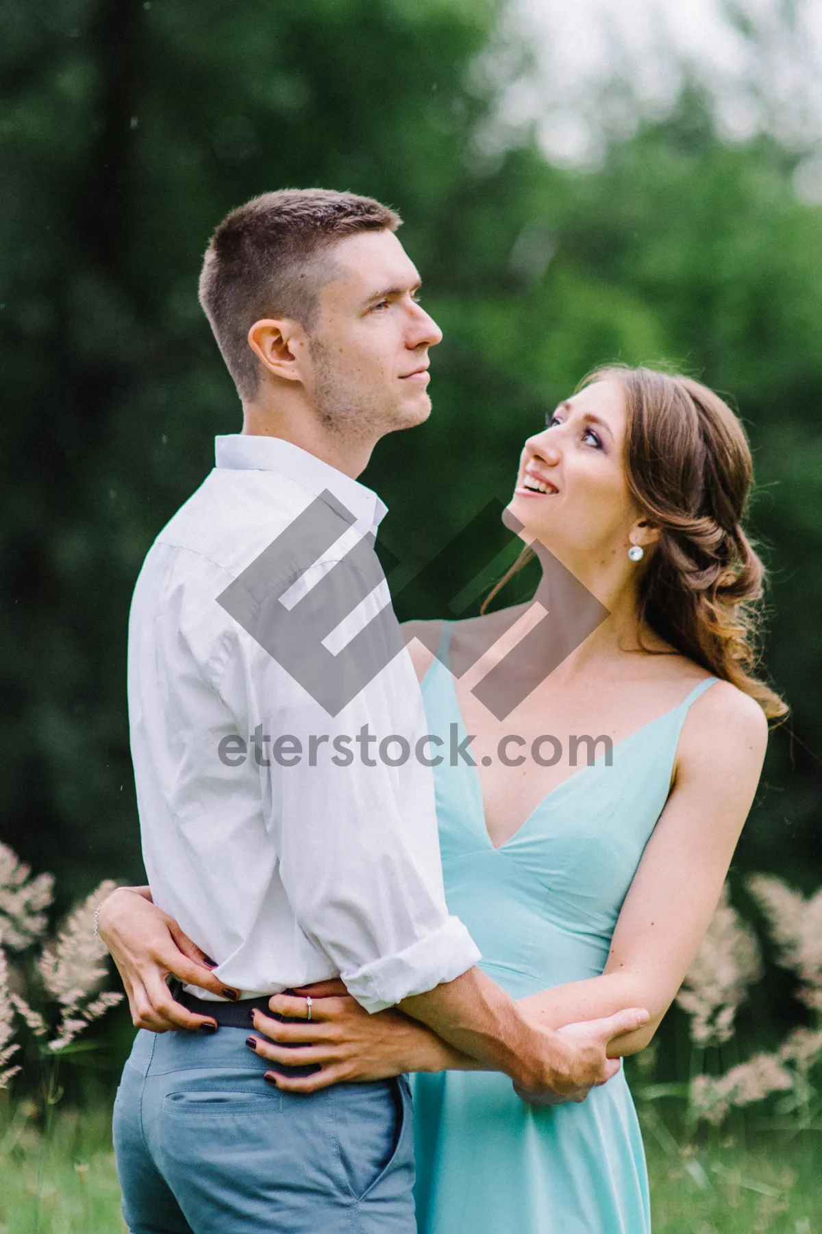 Picture of Happy couple smiling in the park on wedding day.