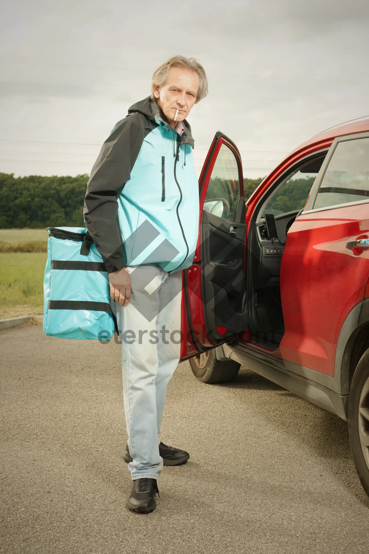 Picture of Adult man driving electric minivan with tool bag.