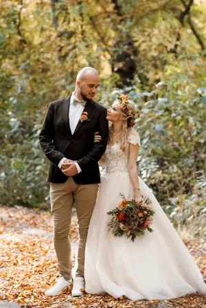 Happy couple in wedding attire smiling outdoors in love.