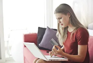 Happy businesswoman working on laptop at home office.