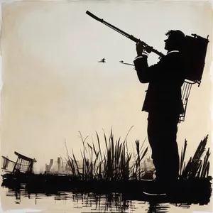 Silhouette of man with gun against sunset sky.