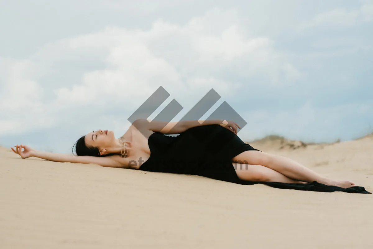 Picture of Attractive brunette model in bikini relaxing on sand