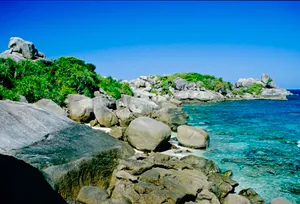 Tropical beach waves under sunny sky. The colors and crystal clear water of the archipelago of the Similan Islands National Park, Thailand, Asia