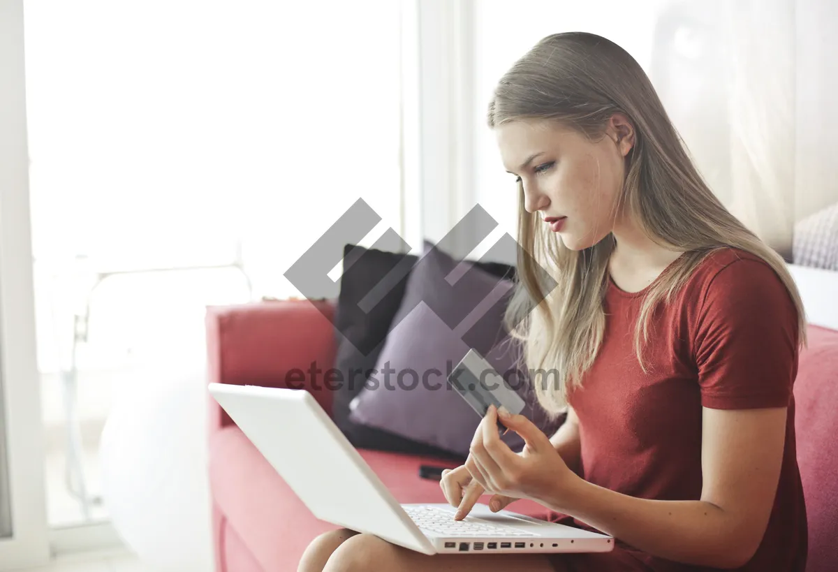 Picture of Happy businesswoman working on laptop at home office smiling.