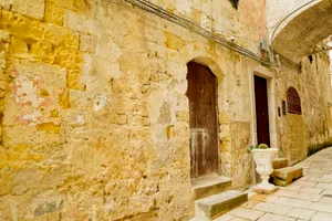 Medieval church with stone walls and arched doorway.