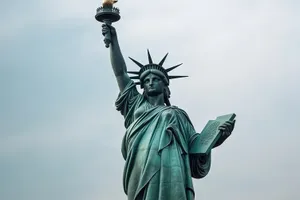 Bronze statue of landmark with city skyline background