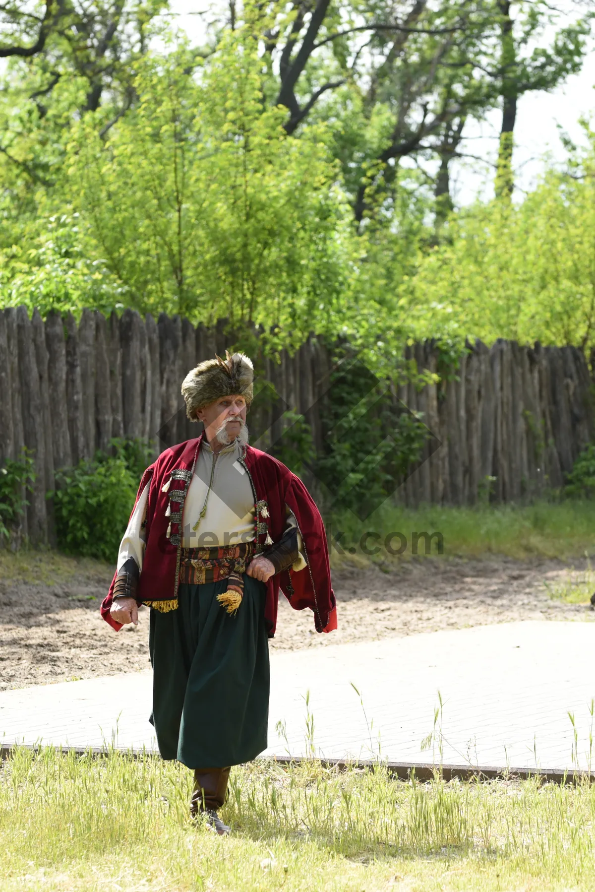 Picture of Person in cloak walking through outdoor forest park.