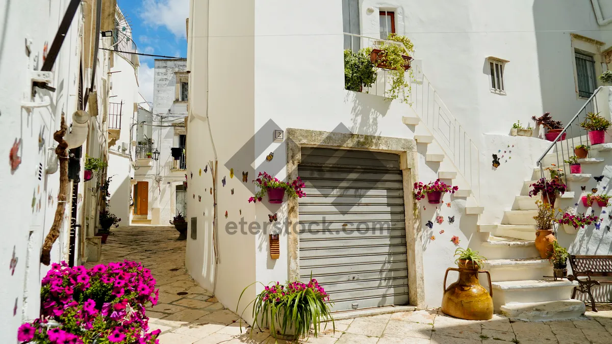 Picture of Old stone house with balcony and flowers in town