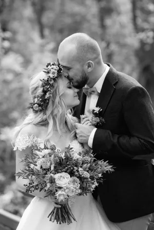 Happy Wedding Couple Outdoors Smiling with Flowers