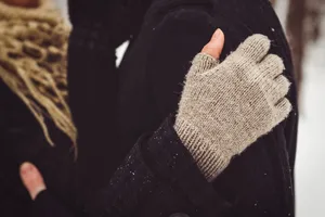 Man wearing glove and mitten on finger