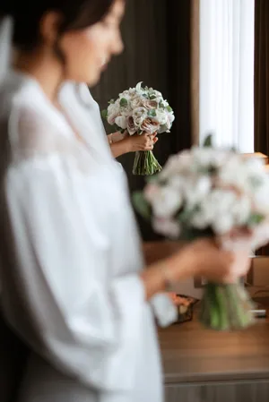 Happy newlywed couple with bouquet of roses at wedding.