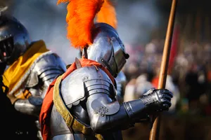 Medieval soldier wearing protective armor and holding sword.