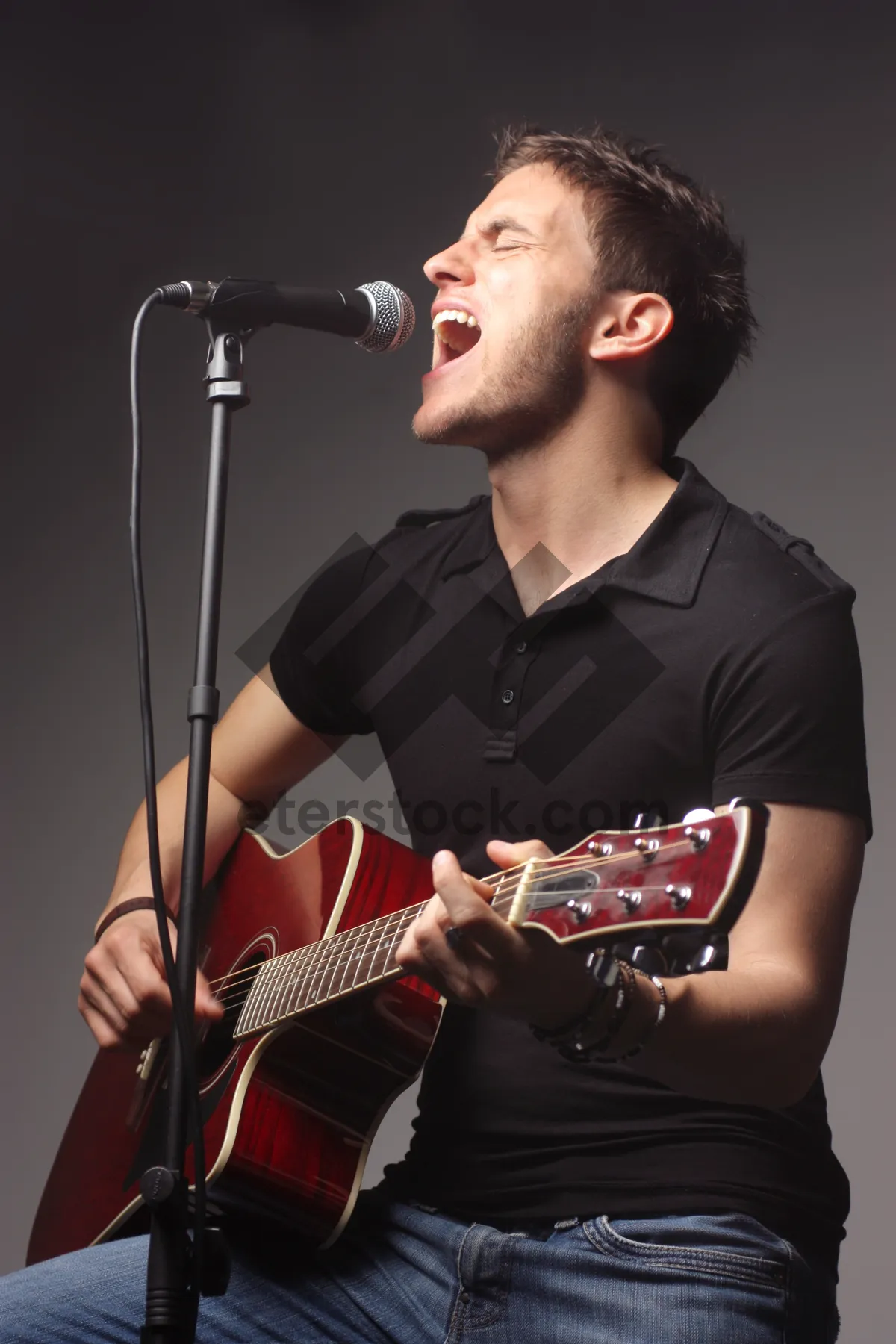 Picture of Attractive male rock singer with guitar on stage portrait