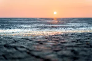 Sunset over tropical beach with calm waves
