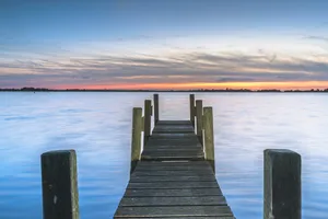 Pier overlooking tropical ocean landscape with wooden boat