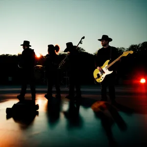 Silhouetted musician playing banjo on windy beach stage