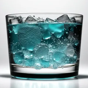 Refreshing cold drink with ice cubes in glass.