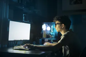 Happy DJ man working at laptop in office.