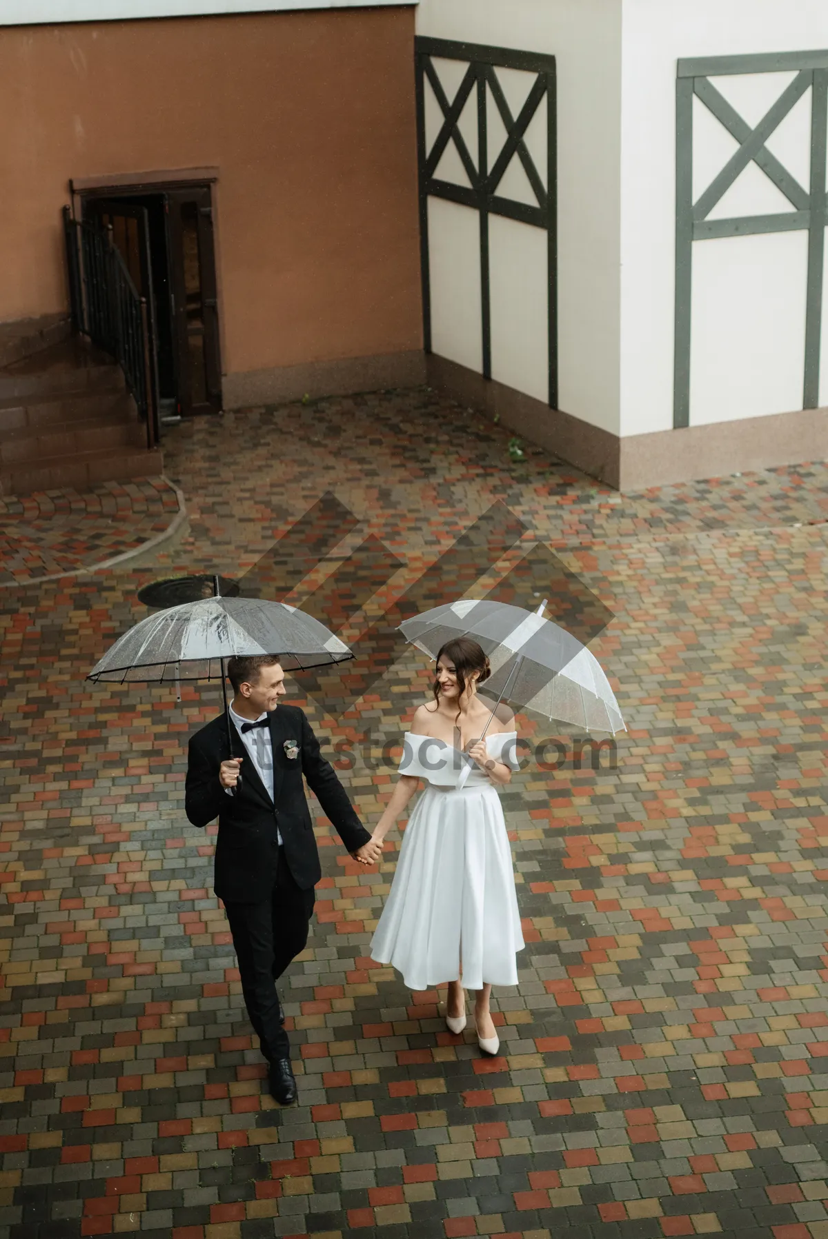 Picture of Happy adult under protective umbrella in rain