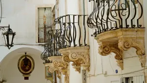 Old building with balcony and menorah sculpture on facade