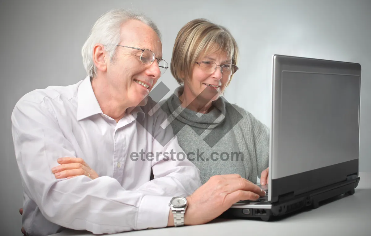 Picture of Happy elderly couple working on laptop at home