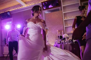 Happy bride in beautiful wedding gown holding bouquet.