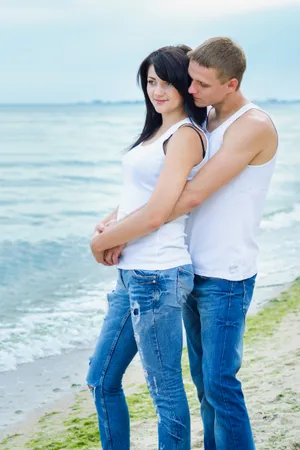 Happy young couple smiling on beach vacation.