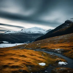 Glistening snow-covered mountain peaks under cloudy sky