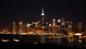 Modern office tower reflecting city lights on water at night