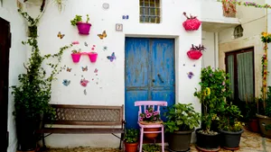 Residential container home with balcony and flower pot decoration.