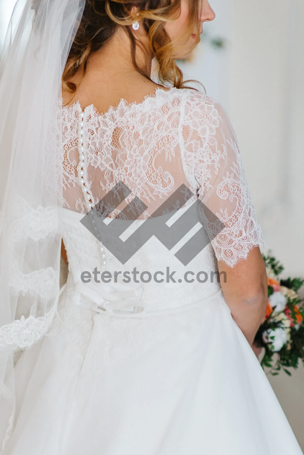 Picture of Attractive bride in a wedding gown holding bouquet