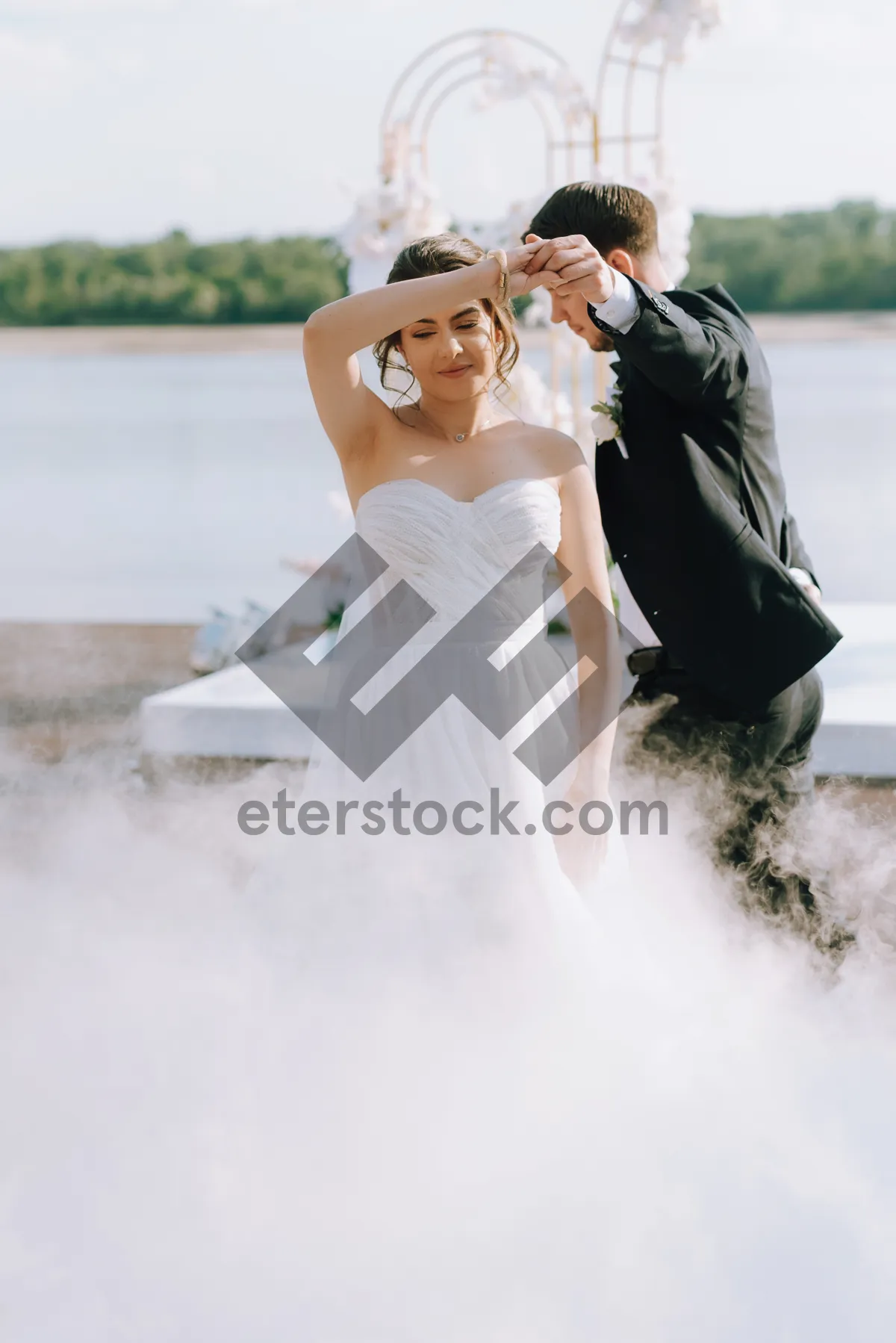 Picture of Happy couple in wedding attire holding flower bouquet