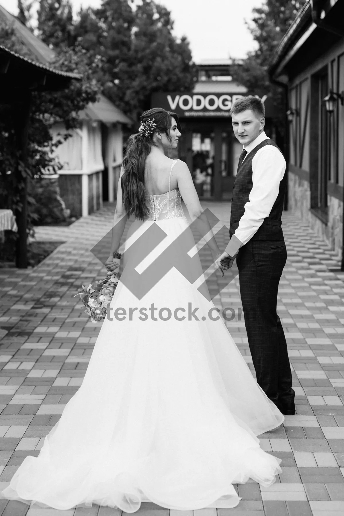 Picture of Happy couple celebrating wedding day with bouquet of flowers