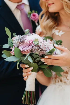 Happy wedding couple with rose bouquet in love.