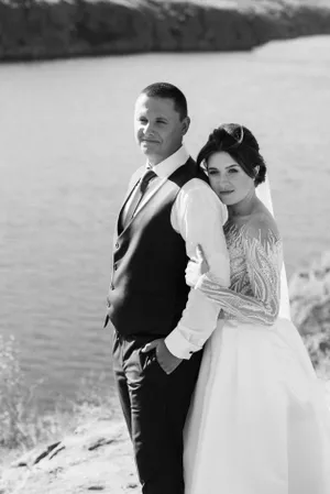 Happy married couple celebrating wedding outdoors with flowers.