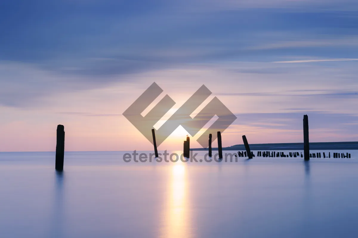 Picture of Sunset silhouette city skyline reflection over water beach.