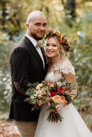 Happy couple celebrating their wedding day outdoors with flowers