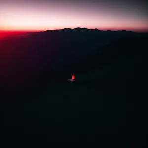 Majestic Horizon: Sun Setting Behind Volcanic Mountains