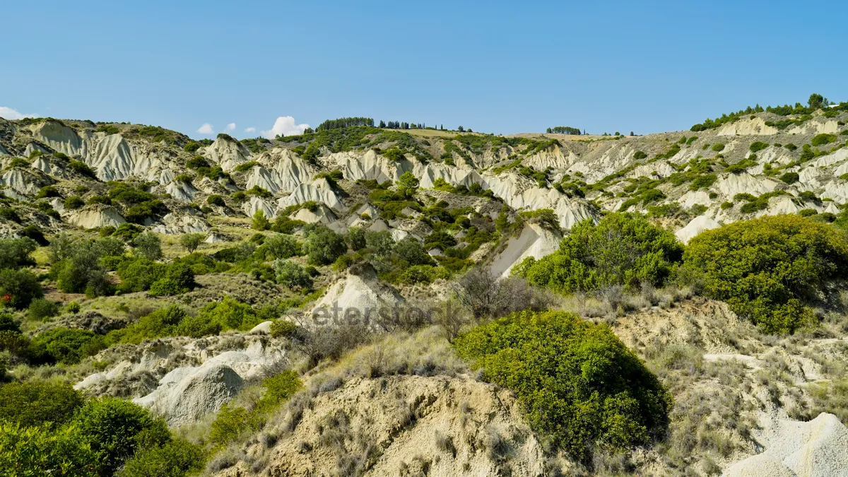 Picture of Mountain landscape with rocky slopes and lush valleys.