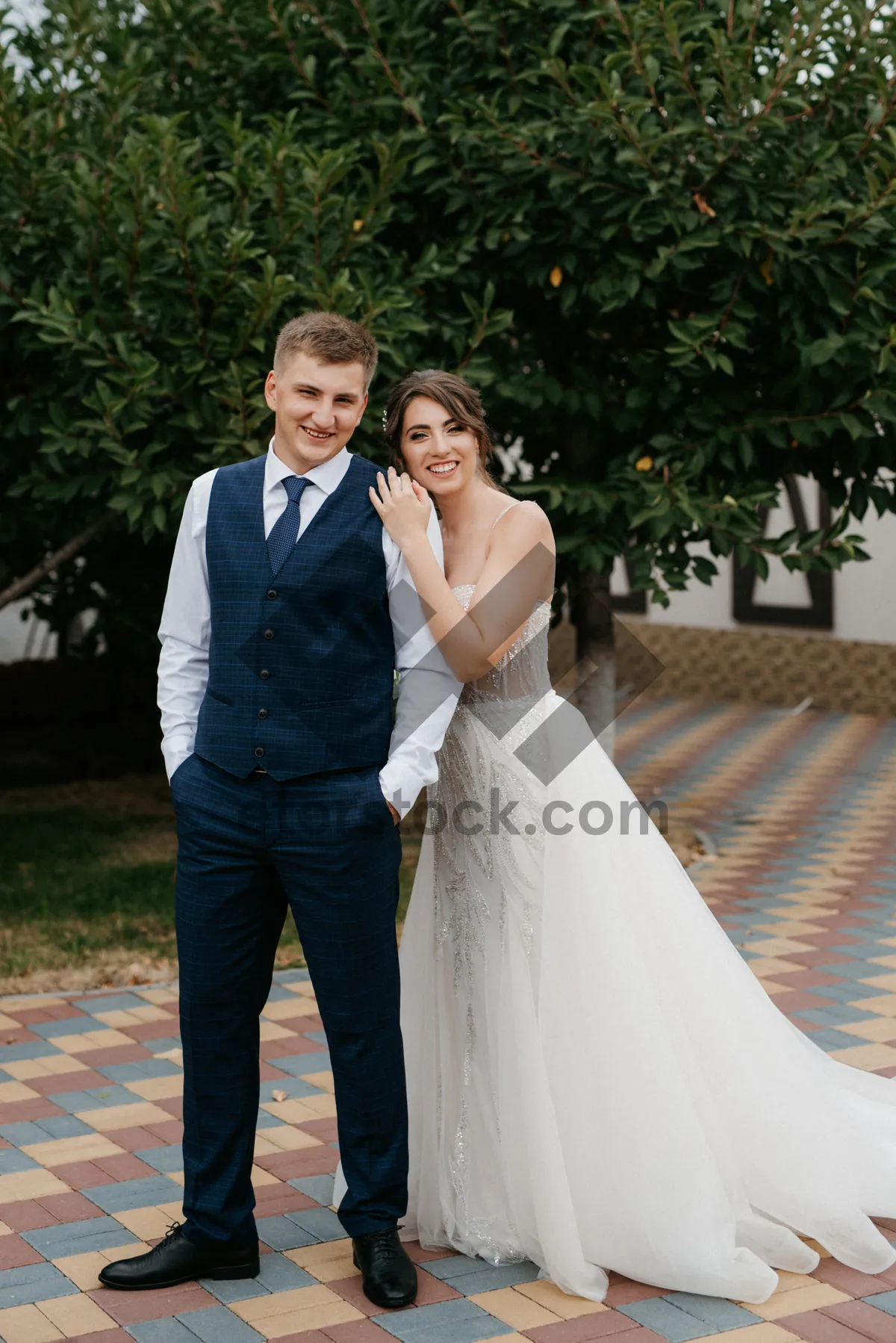 Picture of Romantic wedding couple smiling happily outdoors surrounded by flowers