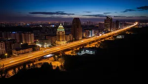 Modern city skyline with suspension bridge at sunset