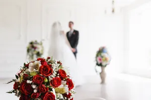 Happy newlywed couple at wedding ceremony with flower bouquet