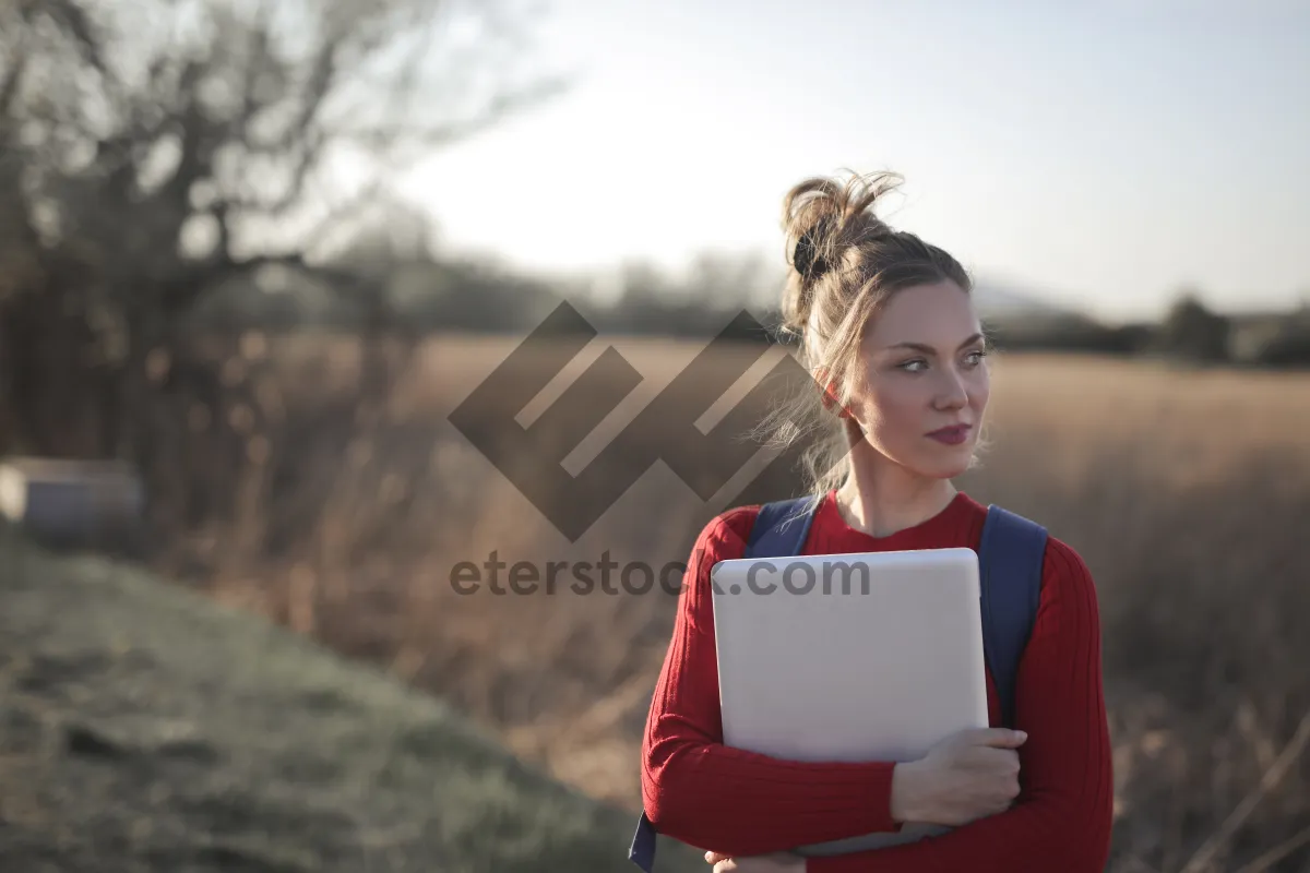 Picture of Happy woman working on laptop in the park.