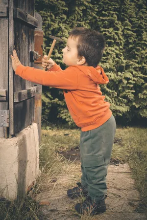 Happy boy playing with bow and arrow in park.