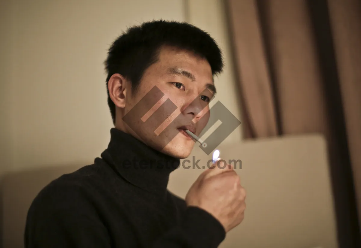 Picture of Attractive male with lipstick applying makeup brush to face.