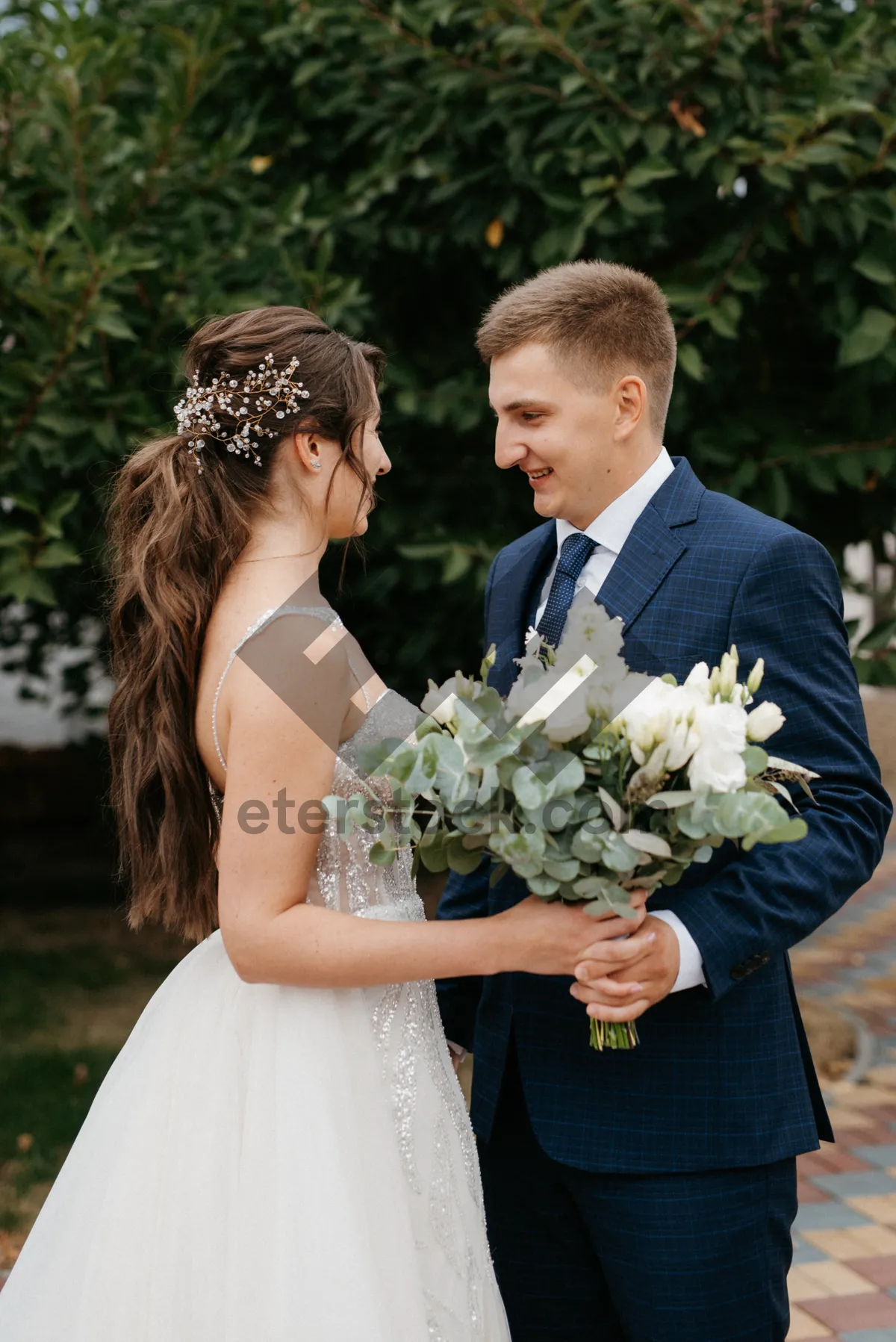 Picture of Happy couple celebrating their wedding outdoors with flowers.