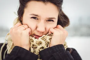 Attractive brunette fashion model smiling with burrito on face.