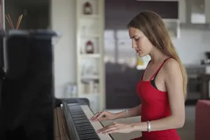 Attractive woman playing piano in cozy living room.